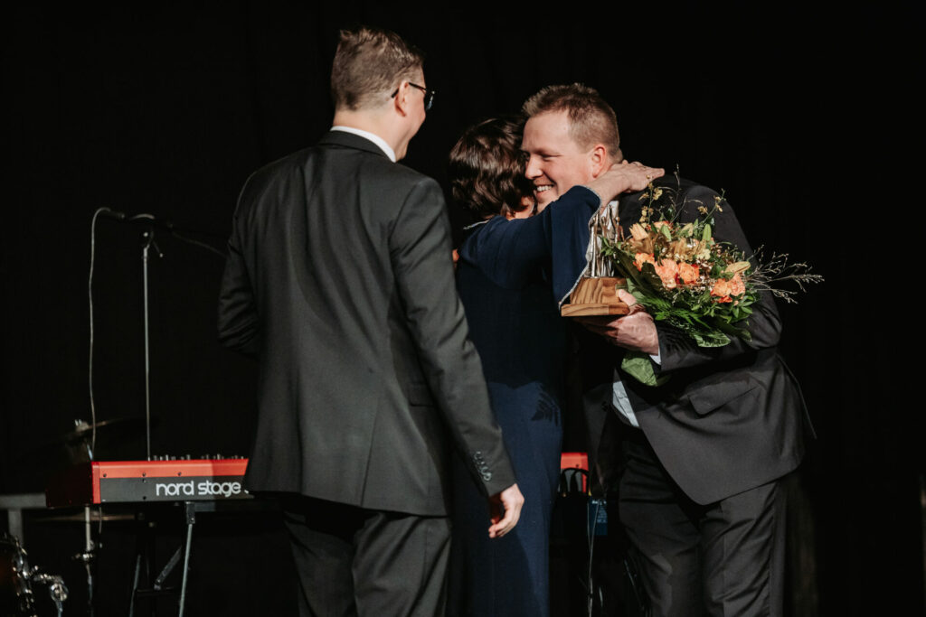 Puualan yrittäja Sami vastaanottamassa palkintoa yrittäjägaalassa. Kuvassa lämmin halaus.