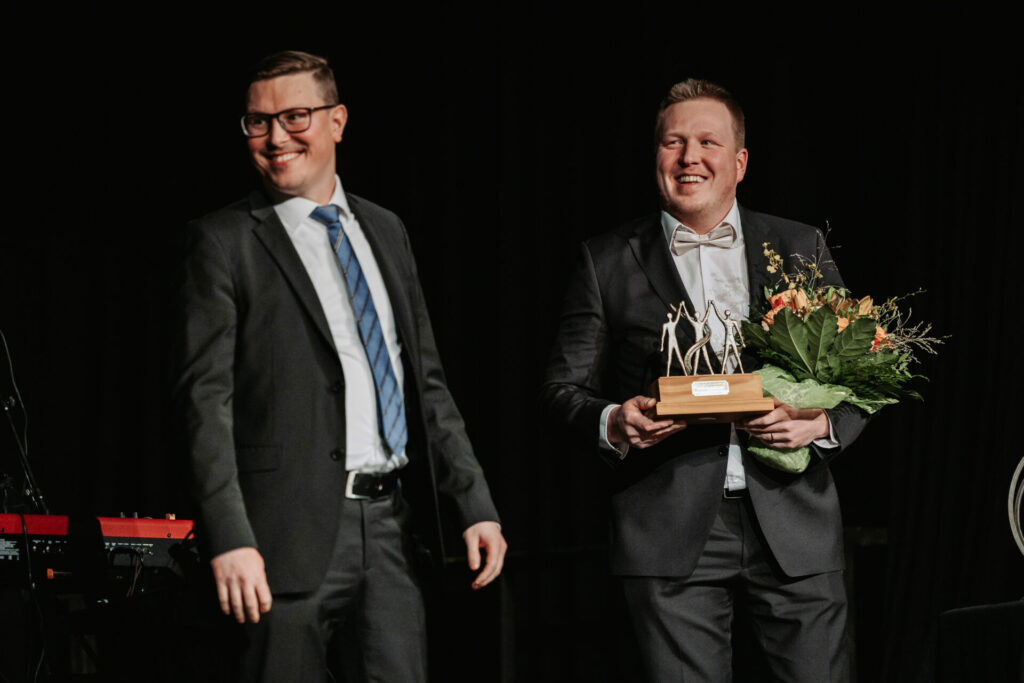 Pieksäwoodin toimitusjohtaja Sami Koskinen vastaanottamassa palkintoa ja kukkia yrittäjägaalassa 2023.